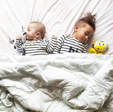 Baby brothers asleep in bed