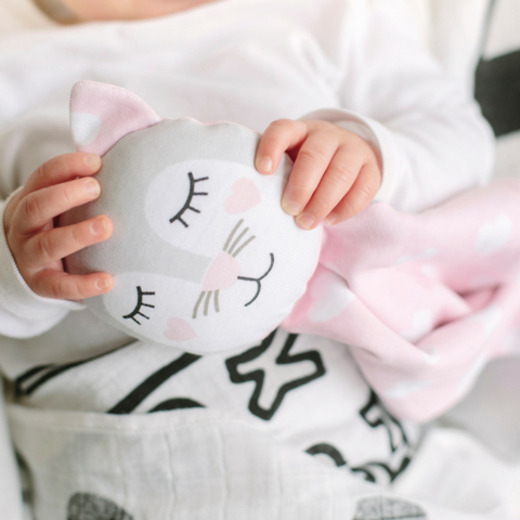 Baby holding a Kippins comforter