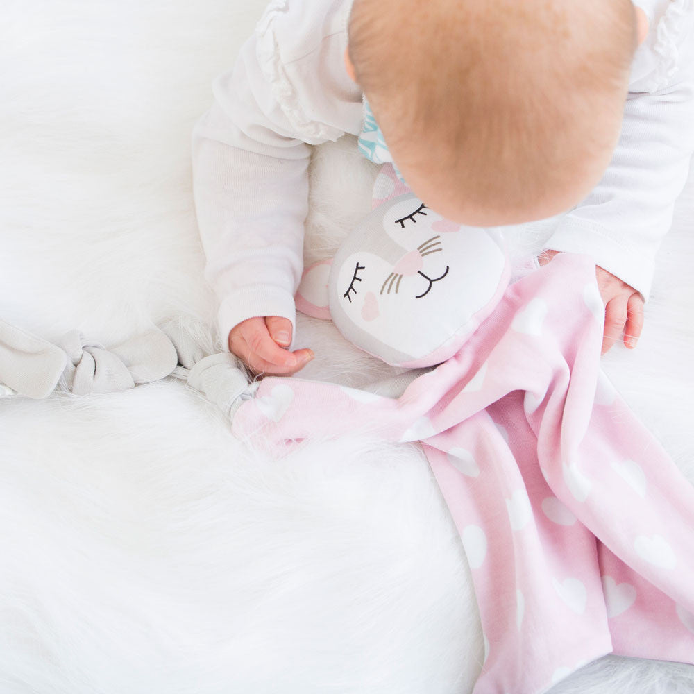 Baby holding Kitty Kippin security blanket