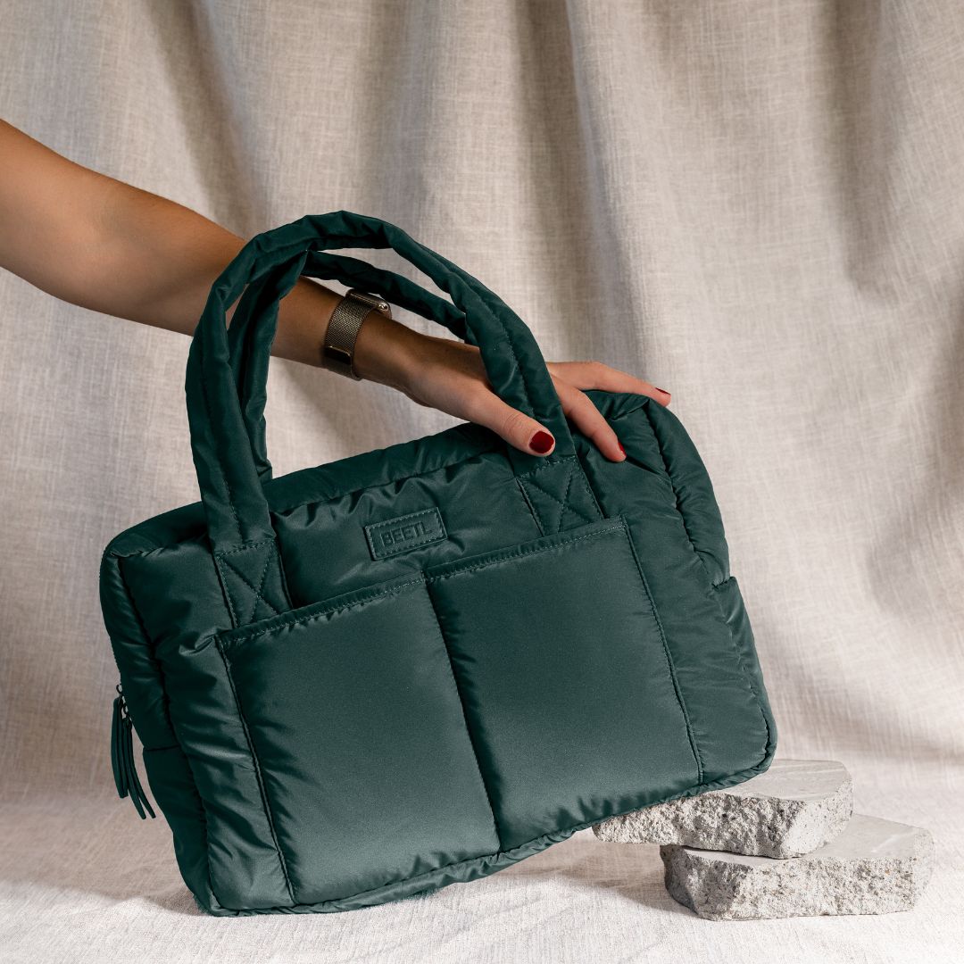 Forest green baby bag by BEETL, stylish and functional with multiple compartments, shown with adjustable straps and carrying handles.