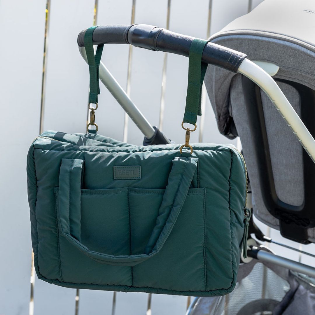Forest green BEETL baby bag with multiple compartments and adjustable straps, designed for convenient parenting on the go.