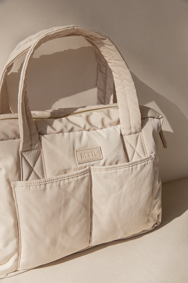 Cream BEETL Baby Bag with multiple compartments and adjustable straps, designed for easy organization and carrying essentials.