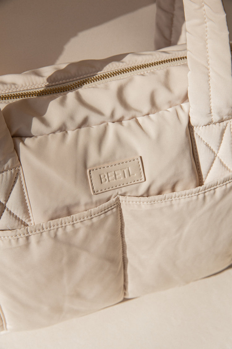 Cream BEETL Baby Bag with multiple compartments, stylish and functional for parents carrying baby essentials.